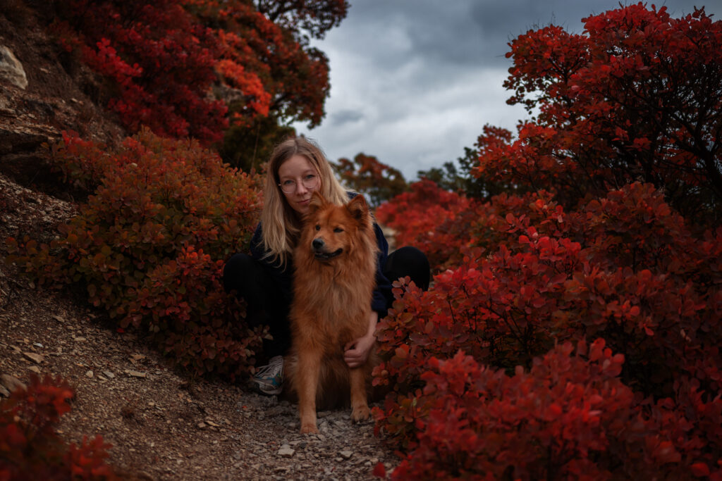 In dieser naturnahen Idylle sehen wir eine liebevolle Frau, die eng mit ihrem treuen Hund umarmt. Das Bild strahlt Harmonie und Zweisamkeit inmitten einer malerischen Natur aus. Die herzliche Umarmung der Frau und die entspannte Pose des Hundes vermitteln das tiefe Band zwischen Mensch und Tier. Eine berührende Szene voller Zärtlichkeit und Verbundenheit in einer natürlichen Umgebung.